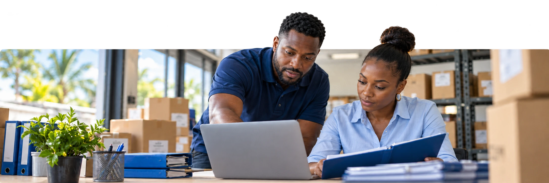 Two Caribbean business owners reviewing their work together